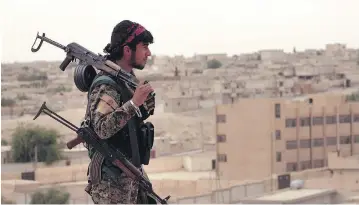  ?? SYRIAN DEMOCRATIC FORCES, VIA AP, FILE ?? A Syrian Democratic Forces fighter looks toward the northern town of Tabqa, Syria. The Trump administra­tion announced it would arm the SDF to recapture the ISIL stronghold of Raqqa, drawing a harsh rebuke from Turkey.