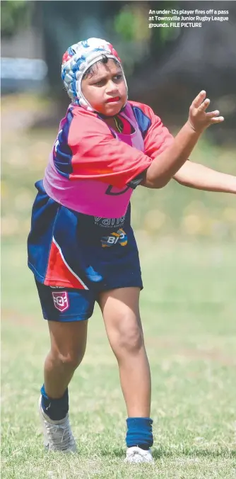  ?? FILE PICTURE ?? An under-12s player fires off a pass at Townsville Junior Rugby League grounds.