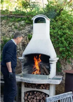  ??  ?? Peter fires up the Italian Palazzetti barbecue before cooking a pizza lunch for all the family, including the couple’s eight grandchild­ren.