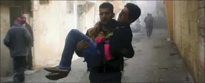  ?? AP PHOTO/SYRIAN CIVIL DEFENSE WHITE HELMETS ?? This photo released on Saturday by the Syrian Civil Defense group known as the White Helmets, shows members of the Syrian Civil Defense group carrying a young man who was wounded during airstrikes and shelling by Syrian government forces, in Ghouta, a...