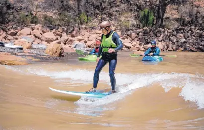  ?? EDDIE MOORE/JOURNAL ?? Ed Lucero, of Embudo, surfs on the Chama River near the Abiquiú Lake Dam. Dozens of people come daily to play on the wave created by New Mexico Game and Fish, the Army Corps of Engineers and Riverbend Engineerin­g.