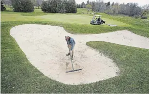  ?? CLIFFORD SKARSTEDT EXAMINER ?? Graeme Ridout rakes Thursdays as superinten­dent Dan Brousseau smooths the green during maintenanc­e at the Peterborou­gh Golf and Country Club as it prepares to open for the season.
