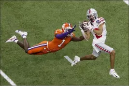  ?? Butch Dill The Associated Press ?? Ohio State receiver Chris Olave catches a touchdown pass over Clemson corner Derion Kendrick on Friday in the Sugar Bowl in New Orleans.