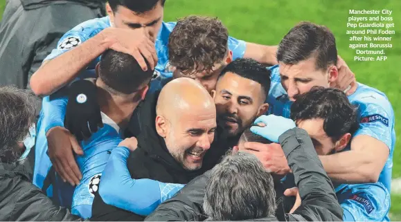  ??  ?? Manchester City players and boss Pep Guardiola get around Phil Foden after his winner against Borussia Dortmund. Picture: AFP