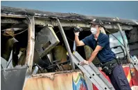  ?? PHOTO: REUTERS ?? A policeman films the wreckage of the bus that crashed and caught fire south of Taipei, killing 26 people.