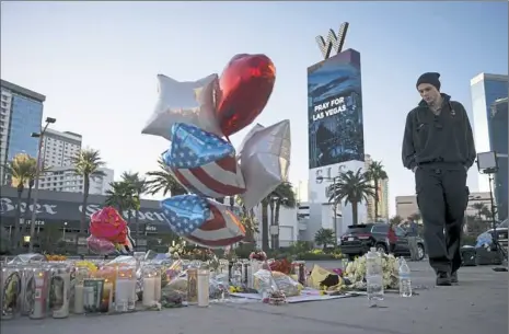  ?? Drew Angerer/Getty Images ?? Matthew Helms, who worked as a medic the night of the shooting, visits a makeshift memorial Tuesday for the victims of Sunday night's mass shooting on the Las Vegas Strip.