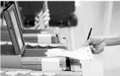  ?? ALAN DIAZ/AP ?? A voter submits his ballot in Hialeah in 2016 primary.
