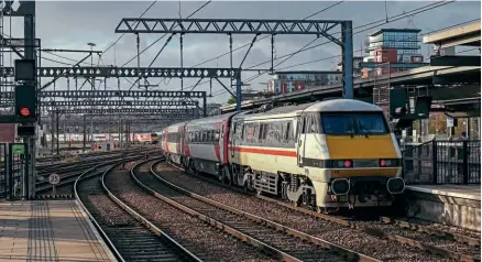  ?? ?? While Leeds has seen its proposed HS2 route cancelled, the IRP is promising to upgrade the East Coast Main Line with improved power and signalling on the key route, allowing lines speeds to be increased to 140mph, returning the aims of the original Intercity 225 project by British Rail when introducin­g the Class 91 fleet. Carrying original Intercity colours in a vinyl wrap, 91119 Bounds Green propels 1A30, the 12.45 to London King’s Cross away from Leeds, as 91105 arrives across West Junction with 1D10, the 10.33 from Kings Cross. Chris Gee