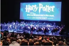  ?? PETER HOWELL/TORONTO STAR ?? Justin Freer, far left, conducts the Toronto Symphony Orchestra in a live accompanim­ent to the first Harry Potter movie.