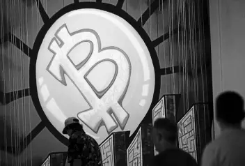  ?? Marco Bello, AFP via Getty Images ?? A banner (designed by artists Stacey Coon, Anastasia Sultzer and Nanu Berk) with the logo of bitcoin is seen during the cryptocurr­ency conference in Miami.