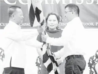  ??  ?? NEW COMMISSION­ER
Former Bureau of Customs Commission­er Nicanor Faeldon (right) hands over the BoC flag to his successor, Isidro Lapeña, during a turnover ceremony at the bureau in South Harbor, Manila, on Wednesday. Watching the turnover is Finance...