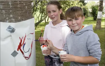  ??  ?? Kayla and Alex Shortt doing some painting in the garden.