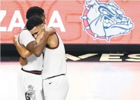  ?? ETHAN MILLER/GETTY ?? Gonzaga’s Joel Ayayi, left, and Jalen Suggs have plenty to hug about. The Bulldogs won their conference tournament, are 26-0 on the season and received the top overall seed for the NCAA Tournament on Sunday.