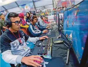  ?? PIC BY LUQMAN HAKIM ZUBIR ?? E-sports players glued to their monitors at the Bukit Jalil National Stadium in Kuala Lumpur yesterday.