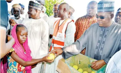  ?? PHOTO: OMIRIN OLATUNJI ?? Borno State Governor Kashim Shettima giving fruits to some displaced persons at a camp in Maiduguri yesterday.