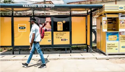  ?? Picture: TOM SAATER/BLOOMBERG ?? A man passes an MTN bus-stop advertisem­ent and roadside kiosk in Lagos, Nigeria.