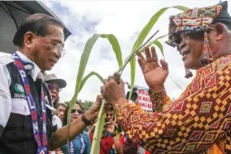  ??  ?? REACHING OUT FOR PEACE – Presidenti­al Adviser on the Peace Process Jesus Dureza (left) receives a stem of grass from tribal chief Larris Masaloon as part of the ritual marking the inaugurati­on of a bridge in Sitio Patil, Barangay Gupitan in Kapalong,...