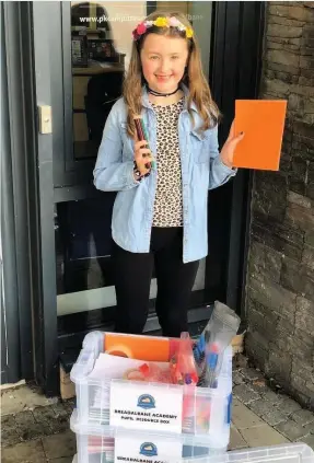  ??  ?? Pens and paper Alba MacDougall, P4 at Breadalban­e Academy, helps herself to a box of student resources provided to help with home schooling during COVID-19