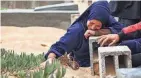  ?? AFP VIA GETTY IMAGES ?? A woman cries over a grave Wednesday at the start of the Eid al-Fitr festival, marking the end of the Muslim holy month of Ramadan, at a cemetery in Rafah in the southern Gaza Strip.