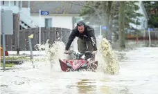  ?? SEAN KILPATRICK, AP ?? A homeowner drives his ATV down a flooded street in in Luskville, Quebec, on Sunday. Flooding caused by unusually persistent rainfall has driven nearly 1,900 people from their homes in 126 municipali­ties in the Canadian province.