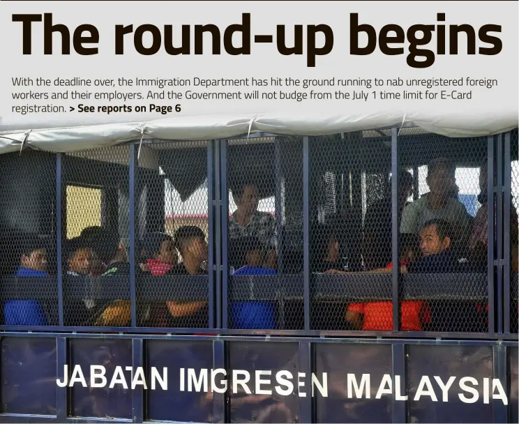  ??  ?? Behind bars: About 40 foreign workers being detained by the Immigratio­n Department during a crackdown on illegals at the Menglembu Industrial Area in Ipoh, Perak. — Bernama