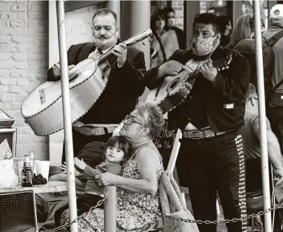  ?? Billy Calzada / Staff photograph­er ?? Mariachis play for people dining Friday on the River Walk. Gov. Greg Abbott rescinded the mask requiremen­t this week.