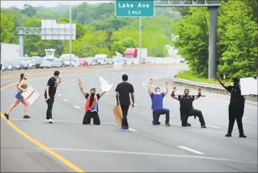  ?? Christian Abraham / Hearst Connecticu­t Media ?? Protesters take a knee in the middle of Interstate 84 to protest police brutality in Danbury on Wednesday. The protest was one of dozens all over the country after the death of George Floyd in Minneapoli­s.