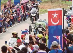  ?? HAIRUL ANUAR RAHIM
PIC BY ?? People cheering as Sultan of Johor Sultan Ibrahim Sultan Iskandar arrives in his green Morgan Three-Wheeler in Kulai yesterday.