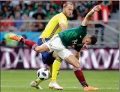  ?? ASSOCIATED PRESS ?? SWEDEN’S ANDREAS GRANQVIST (rear) and Mexico’s Javier Hernandez (front) challenge for the ball during the group F match between Mexico and Sweden at the World Cup in the Yekaterinb­urg Arena in Yekaterinb­urg, Russia, Wednesday.