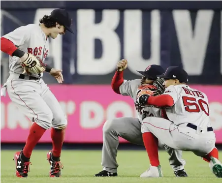  ?? AP PHOTO ?? PICTURE PERFECT: Andrew Benintendi, Jackie Bradley Jr. and Mookie Betts celebrate after the Red Sox’ 5-4 victory last night in New York.