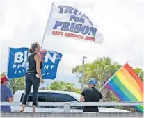  ?? AMY BETH BENNETT/SOUTH FLORIDA SUN SENTINEL ?? Danielle Szasz, of Boca, yells out to a passing car while protesting President Trump with Dirk Van Onselder and Richard Voorhees, both of Fort Lauderdale, in Jupiter on Tuesday.