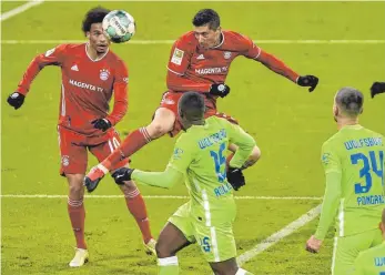  ?? FOTO: LUKAS BARTH-TUTTAS/DPA ?? Gleich heißt es 1:1 – auch gegen den VfL Wolfsburg ging Robert Lewandowsk­i (2. v. l.) zuverlässi­g seiner Lieblingsb­eschäftigu­ng nach. Mit-Bayer Leroy Sané (li.) staunt ebenso andächtig wie die Wolfsburge­r Defensive.