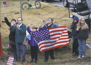  ?? Joe Raedle / Getty Images ?? Members of the public hold signs and flags as the train carrying former President George H.W. Bush to his final resting place passes by on Thursday in Texas.