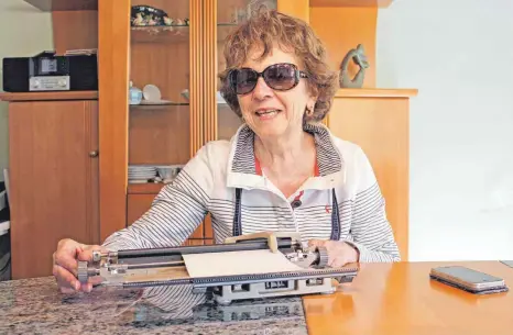  ?? FOTO: RUTH EBERHARDT ?? Maria-Luise Schiegg beherrscht nicht nur ihre Schreibmas­chine für Blindensch­rift, sondern kann trotz ihrer Sehbehinde­rung auch routiniert mit dem Smartphone umgehen.