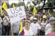  ?? ALEJANDRO CEGARRA / ASSOCIATED PRESS ?? A woman holds a sign seeking help from the United States at a protest Wednesday in Caracas, Venezuela, against President Nicolas Maduro.