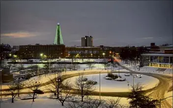  ?? Robert mills /lowell sun ?? downtown lowell roads, such as the rotary in front of the tsongas center at umass lowell, were fairly clear thursday evening, though side roads were still slippery. the wannalanci­t mills smokestack christmas tree is seen at rear, along with umass lowell’s Fox Hall.