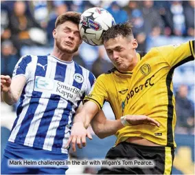  ?? ?? Mark Helm challenges in the air with Wigan’s Tom Pearce.