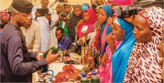  ??  ?? Vice-President Yemi Osinbajo ( L) admiring the products of beneficiar­ies of FG’s interest-free loans dubbed GEEP-MarketMoni at an interactiv­e session with the Vice-President in Kano…recently