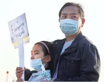  ?? PHOTOS BY JOE RONDONE/THE COMMERCIAL APPEAL ?? Jing Zhu and his daughter Yuqing, 9, join protesters on Sunday.