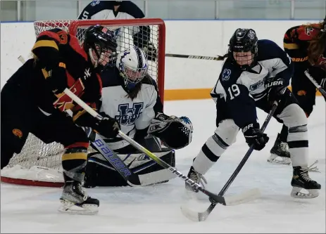  ?? STEVEN MAH/SOUTHWEST BOOSTER ?? Wildcats veteran Evangeline Hill (right) tried to clear the puck away from Regina’s Berlin Lolacher to prevent a scoring chance on goaltender Paige Fischer during a 6-1 loss on Sept. 27.