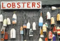  ?? CAROLYN BAUMAN/FT. WORTH STAR-TELEGRAM ARCHIVES ?? Lobster pot marker floats adorn the wall of a business in Cape Neddick, Maine. Scientists have warned of an early lobster season, but locals say so far, there hasn’t been enough to bring down prices.