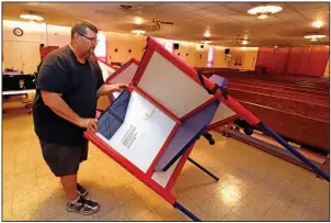  ?? (AP/Gene J. Puskar) ?? Patrick Lathem packs up voting equipment Tuesday at a polling place in Our Lady of Lourdes church in Wintersvil­le, Ohio, after Gov. Mike DeWine declared a health emergency to halt the state’s primary election. More photos at arkansason­line.com/318electio­ns/.