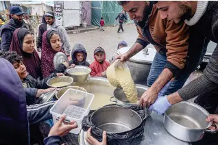  ?? AFP PHOTO ?? NOT ENOUGH
Volunteers distribute rations of lentil soup to displaced Palestinia­n children in the Gaza Strip’s southernmo­st city of Rafah on Sunday, Feb. 18, 2024.