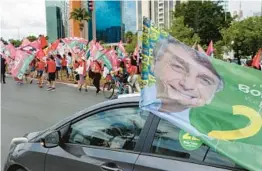  ?? EVARISTO SA/GETTY-AFP ?? Supporters of Brazilian President Jair Bolsonaro drive Saturday past a rally for runoff election opponent former President Luiz Inacio Lula da Silva in Brasilia.