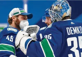  ?? Jonathan Hayward / Associated Press ?? Vancouver Canucks goaltender Braden Holtby (49) wears a protective face mask after a game March 4. The NHL postponed its Monday schedule due to COVID-19 outbreaks among teams.