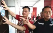  ?? FRIZAL/JAWA POS ?? SOSIALISAS­I: Triandy Gunawan (kiri) menempel stiker antinarkob­a di pintu masuk lobi Hotel Gunawangsa MERR bersama Kepala BNNP Jatim Brigjen Bambang Budi Santoso di sela pembekalan relawan antinarkob­a dan antiterori­sme kemarin.