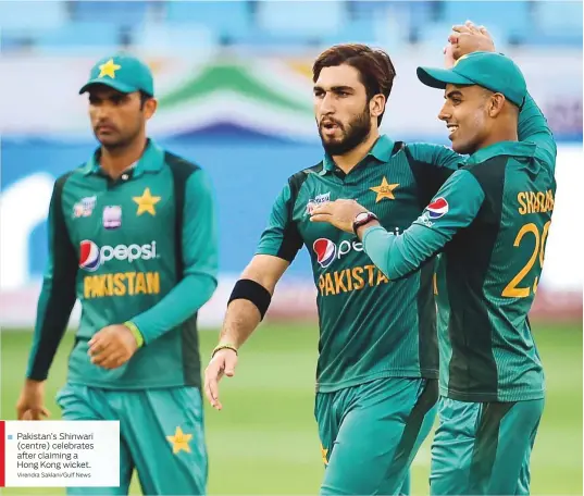  ?? Virendra Saklani/Gulf News ?? Pakistan’s Shinwari (centre) celebrates after claiming a Hong Kong wicket.