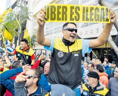 ??  ?? Taxifahrer bei einem Protest gegen Uber in Buenos Aires. Seine Fahrer sieht das US-Unternehme­n als selbststän­dige Dienstleis­ter – vieles spricht aber dafür, sie als Arbeitnehm­er zu klassifizi­eren.