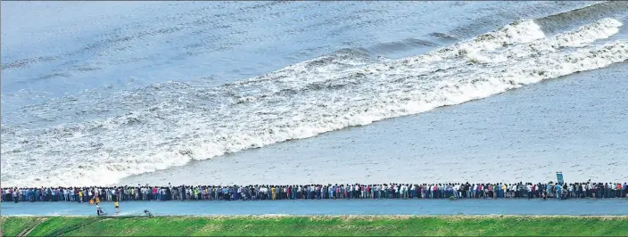  ?? TANG HUASEN / FOR CHINA DAILY ?? Thousands of people gather on the bank of the Qiantang River last year to get a view of the annual tidal bore in Hangzhou, Zhejiang province.