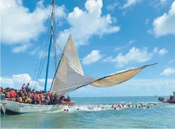  ?? COURTESY ?? Several people from a Haitian migrant boat jump in the water off the Ocean Reef community in north Key Largo on Aug. 6. They were part of a large migrant group of hundreds of people who arrived in an overloaded sailboat. Another sailboat carrying Haitian migrants arrived in the Middle Keys city of Marathon on Monday.